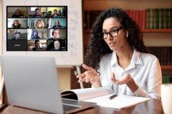 Woman wearing eyeglasses and wireless earbuds, talking to webcam, explaining